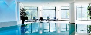Das Bewegungsbad - Schwimmbad der Max Grundig Klinik mit Fensterfront und Liegestühlen