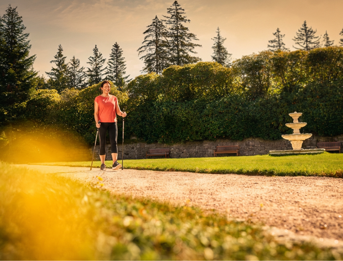 Frau läuft mit walking Stöcken im Park