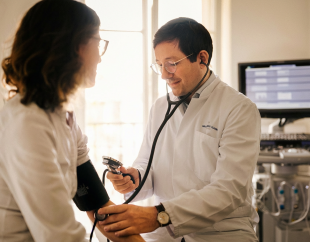 Prof. Dr. med. Timo Heidt misst Blutdruck einer Patientin