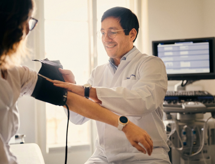 Prof. Dr. med. Timo Heidt misst Blutdruck einer Patientin