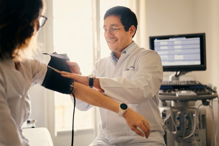 Prof. Dr. med. Timo Heidt misst Blutdruck einer Patientin