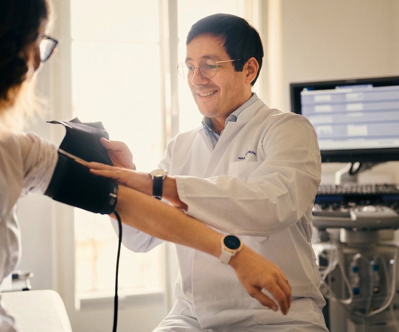 Prof. Dr. med. Timo Heidt misst Blutdruck einer Patientin